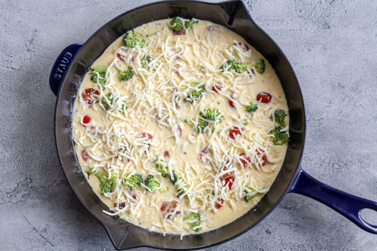 a pan with quiche ingredients and cheese