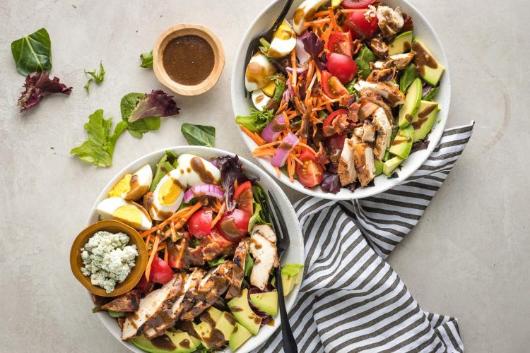 Finished Cobb salads in bowls, ready to serve.