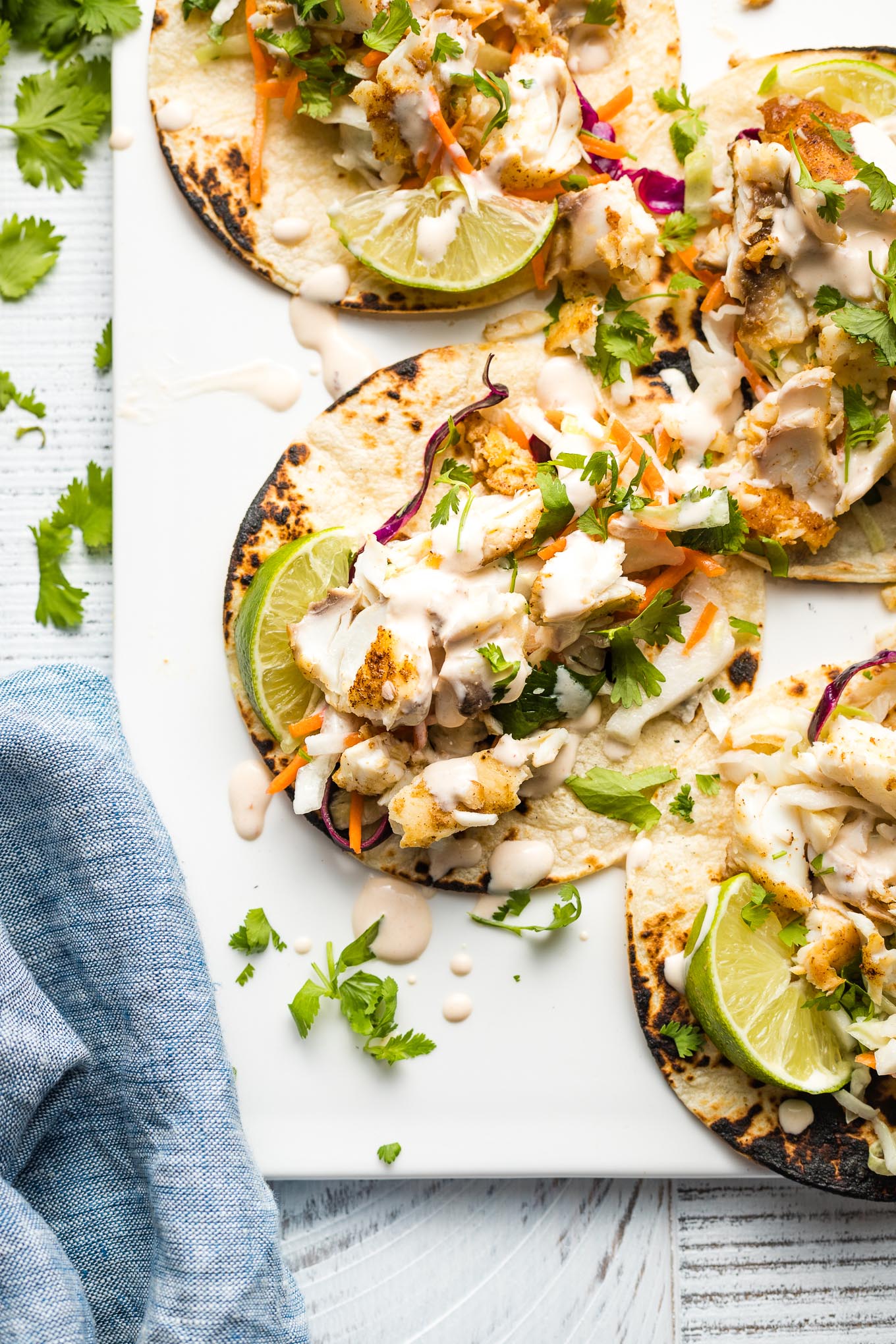 Fish tacos drizzled with crema.
