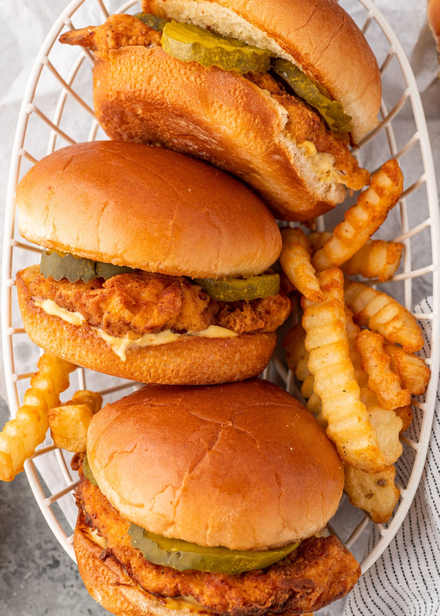 Crispy chicken sandwiches served with fries in a basket.