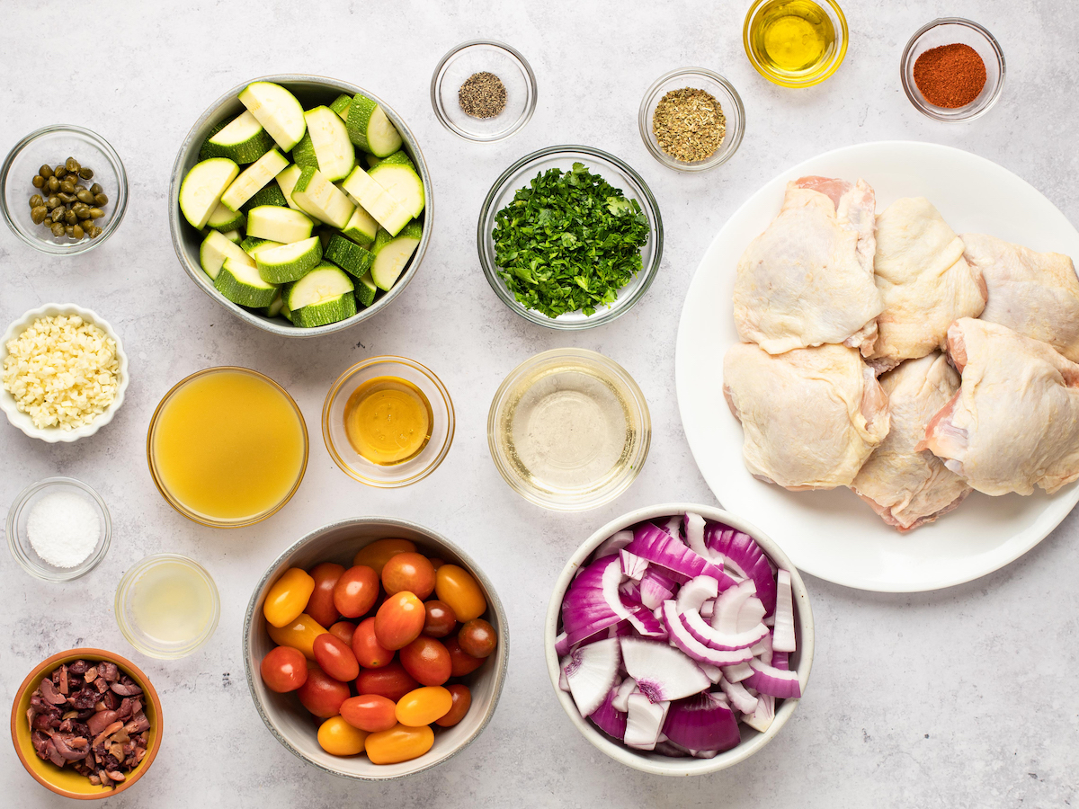 Raw chicken thighs, vegetables and sauces divided into small portions.