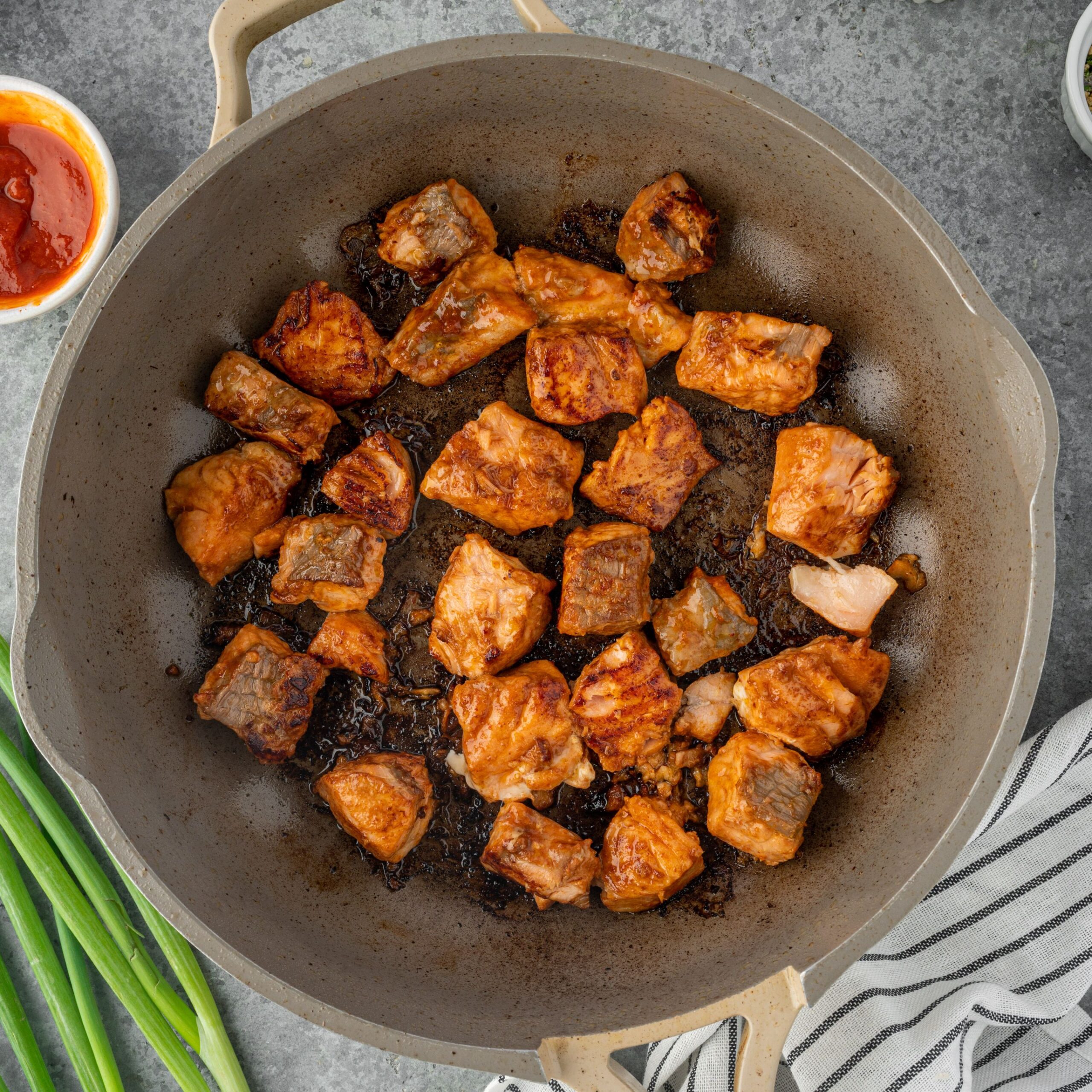 Searing salmon pieces in a skillet.