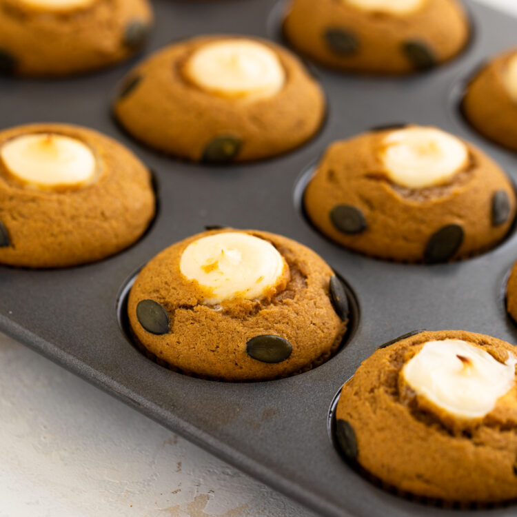 Pumpkin cream cheese muffins baked in a muffin tin.