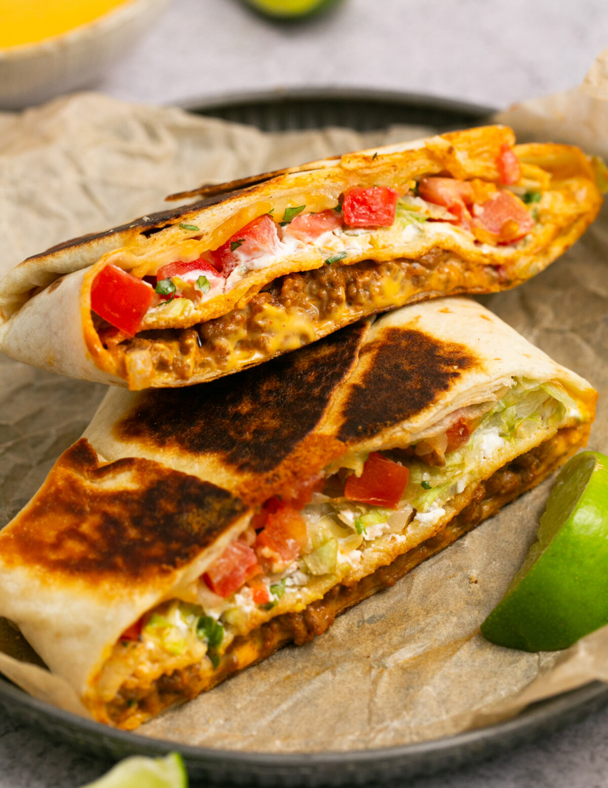 a cheesy beef crunchwrap supreme cut in half