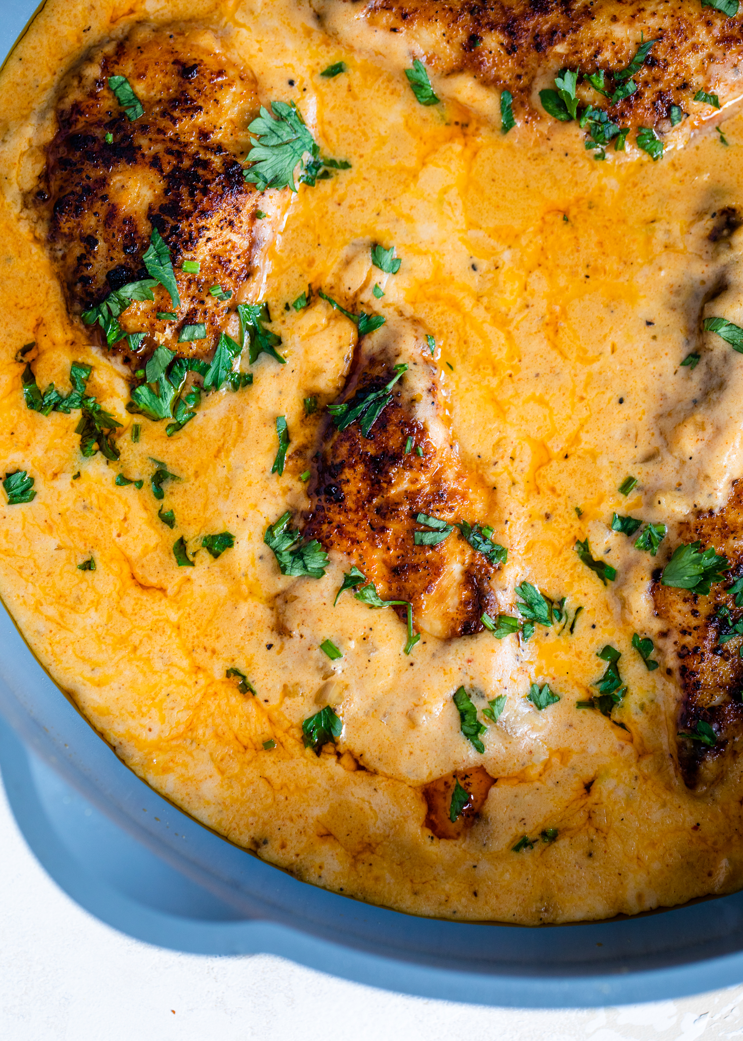 Cajun chicken cooking in a creamy sauce.