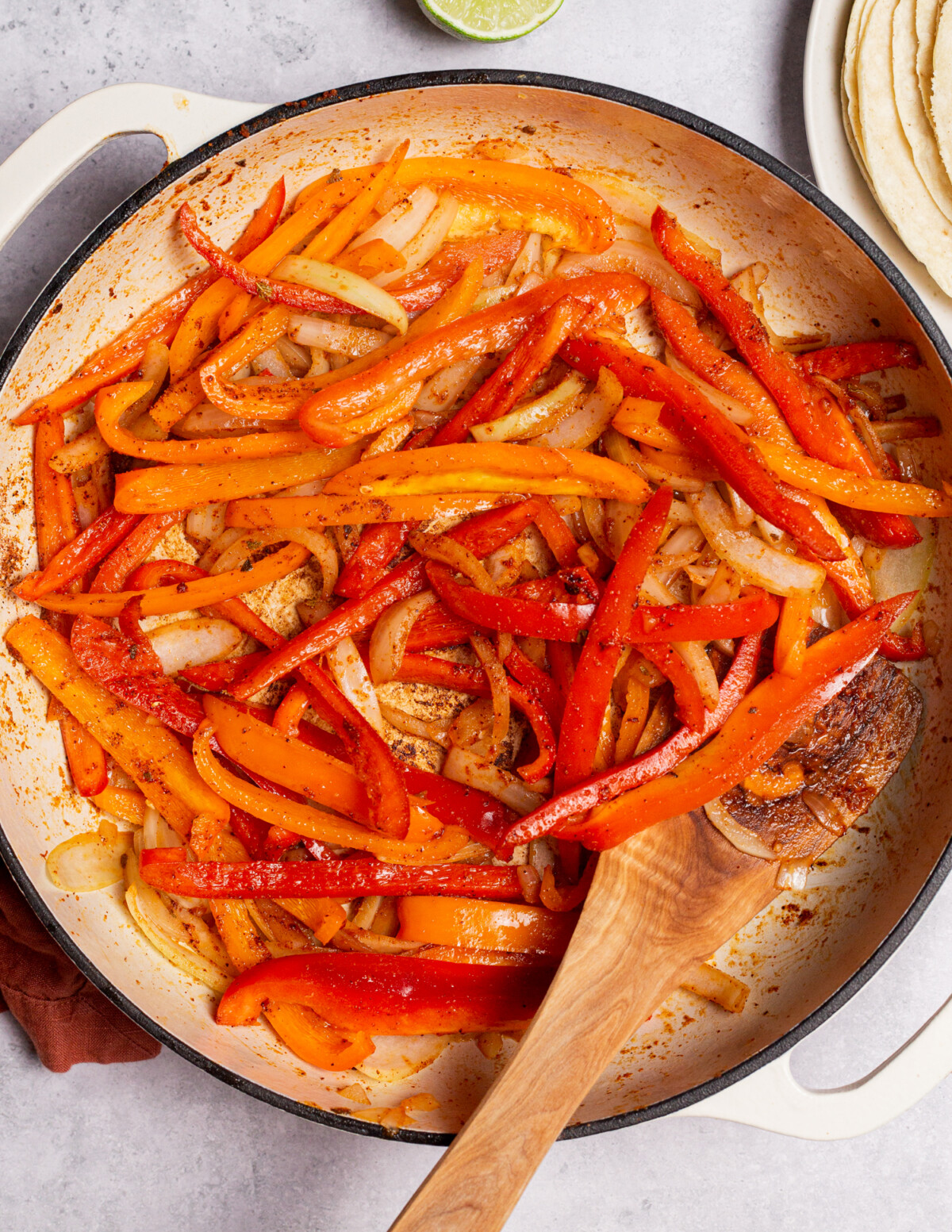 Sautéing bell peppers and onions in a skillet.